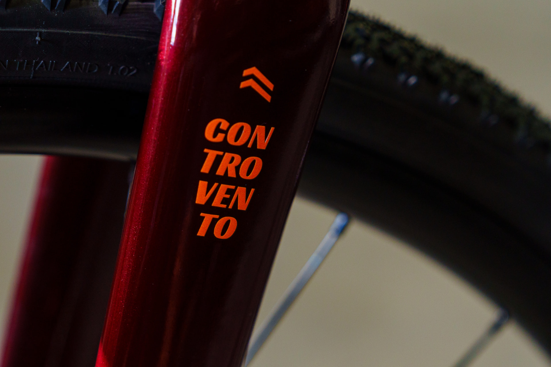 Close-up of the orange Controvento decal on the burgundy steel fork