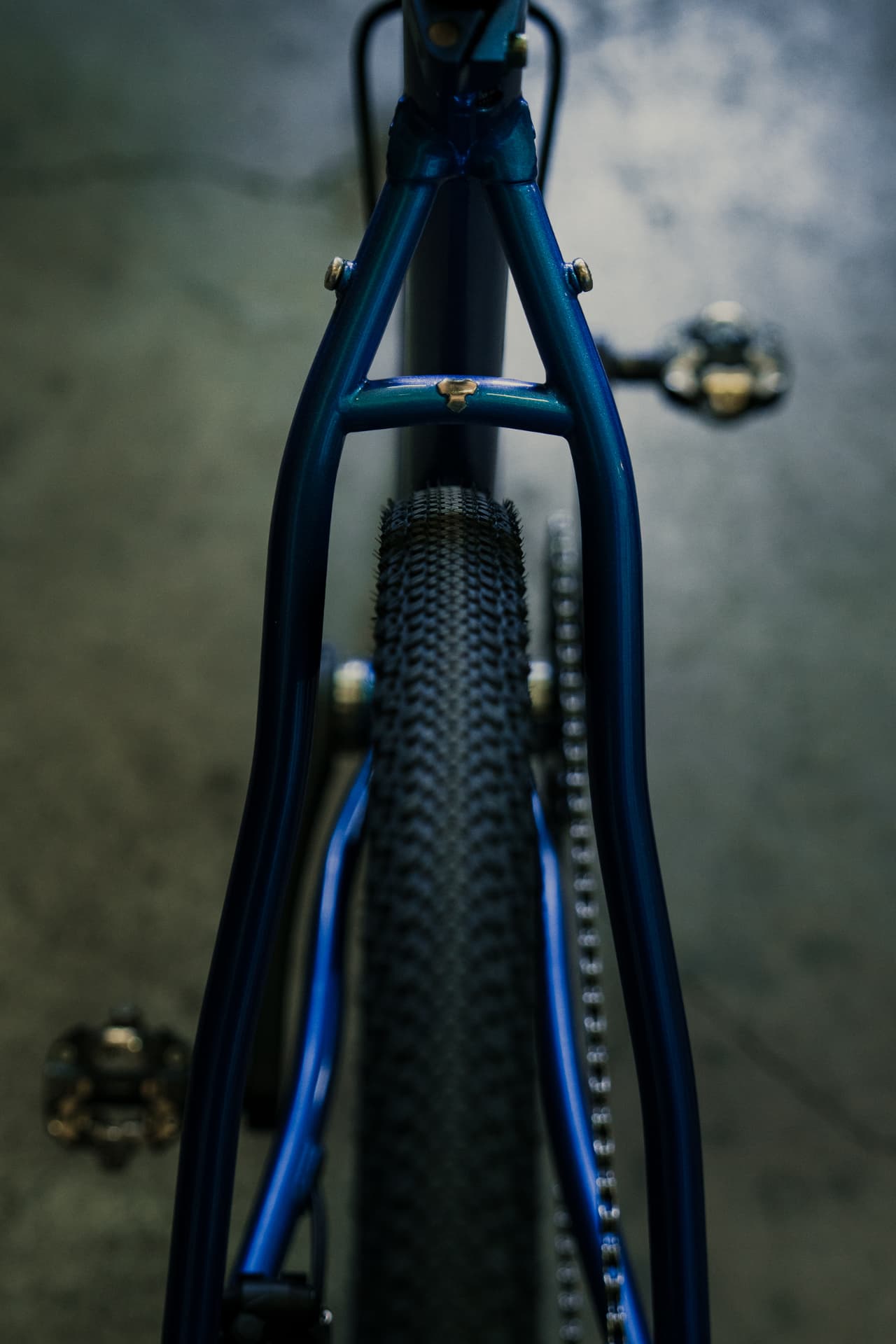 Top-down view of the blue Controvento rear triangle with brazed bridge and gravel tyre