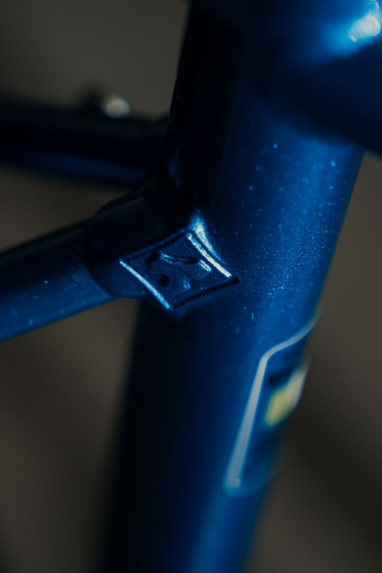 Macro of the seat cluster and engraved Tommasini mark on the metallic blue Controvento